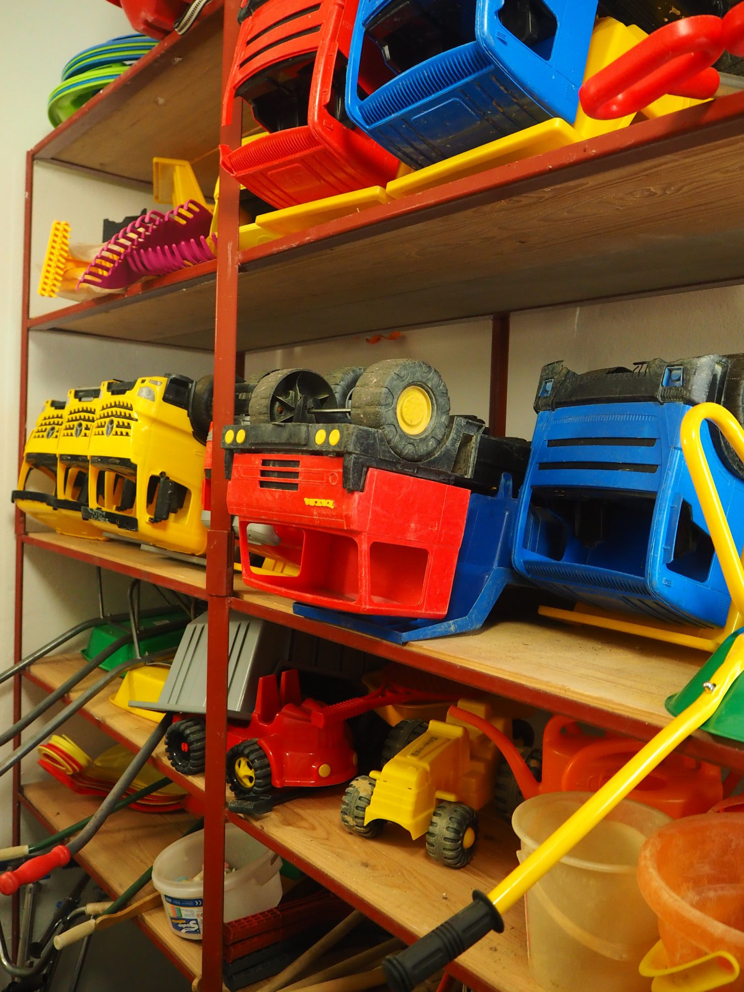Plastová auta a další hračky pro použití na školní zahradě